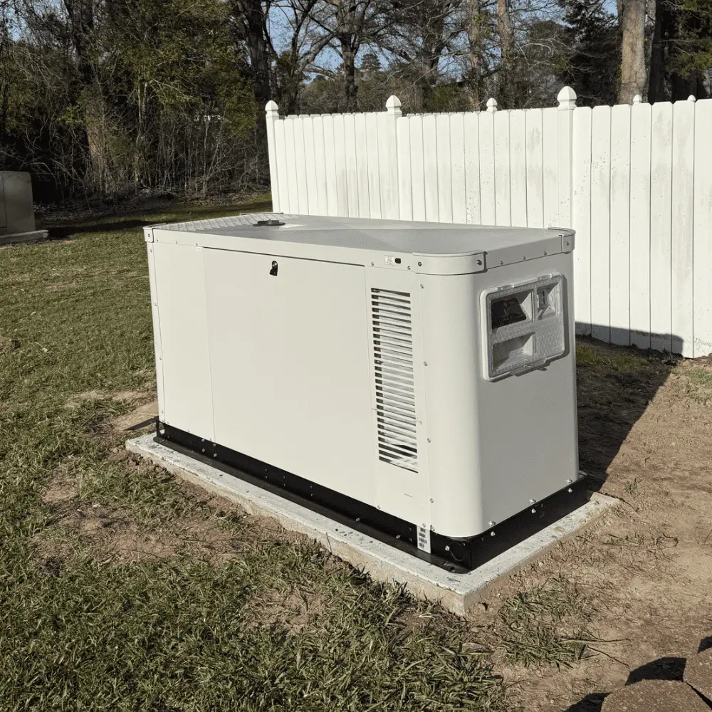 Liquid-cooled generator installed in a yard, surrounded by grass and a white picket fence, representing Bigfoot Electric & AC's generator services in Central Louisiana.