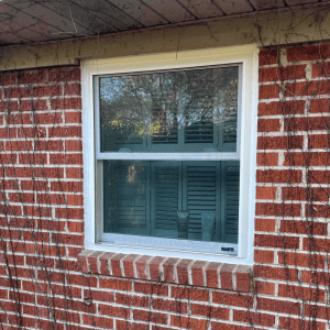 Energy-efficient double-hung window installed in a brick wall, showcasing modern design for improved comfort and performance in Central Louisiana homes.