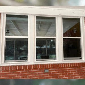 Energy-efficient double-hung windows with white frames, showcasing modern design and natural light in a home setting, relevant to window replacement services in Central Louisiana.